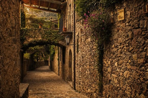 Stone street with arches and balconies in the historic center of Mura.