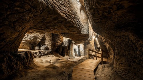 Interior of the Toll Caves in Moià with rock formations and a wooden walkway.