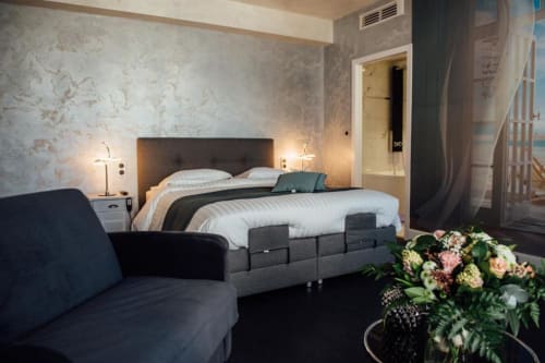 Spacieuse Chambre Double Supérieure à l'Hôtel Amirauté La Baule avec lit élégant, coin salon et arrangement floral frais