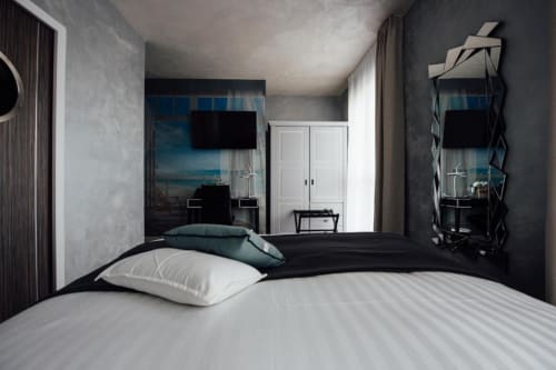Modern double bedroom at Hôtel Amirauté La Baule with city view, flat-screen TV, spa bath, and contemporary decor