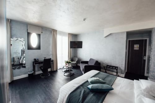 Chambre double moderne à l'Hôtel Amirauté la baule avec lit, coin salon, salle de bain privée et vue sur le jardin
