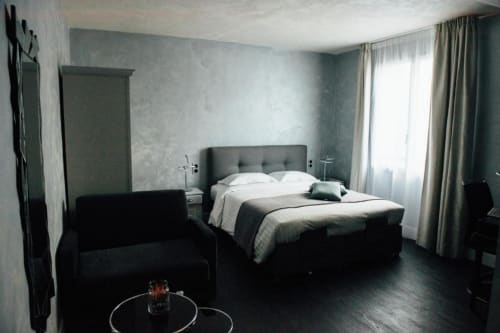 Modern hotel bedroom at Hôtel Amirauté la baule with double bed, black armchair, and garden views