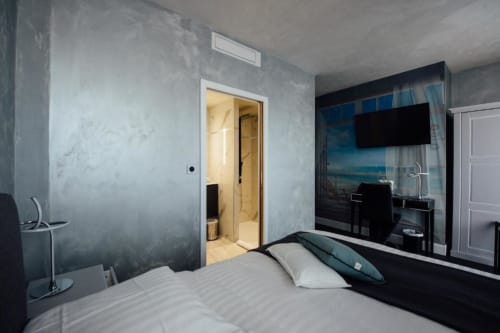 Modern double bedroom at Hôtel Amirauté La Baule with flat-screen TV, contemporary furnishings, and en-suite bathroom