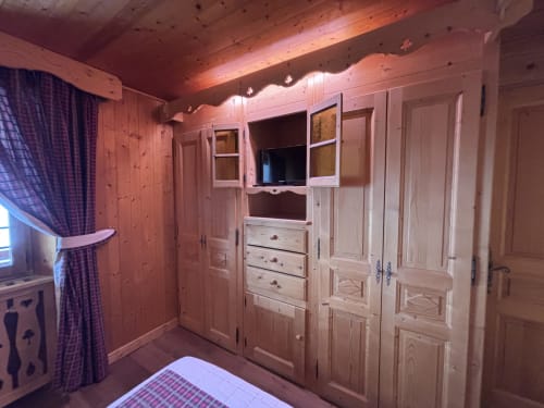 Chambre rustique à Chez Francine avec mobilier en pin, armoire intégrée, éclairage chaleureux et literie à carreaux à Notre Dame