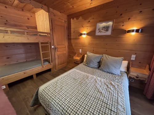 Chambre de chalet en bois avec lit queen-size, lits superposés et décoration de refuge montagnard chez Chez Francine, Notre Dame de Bellecombe