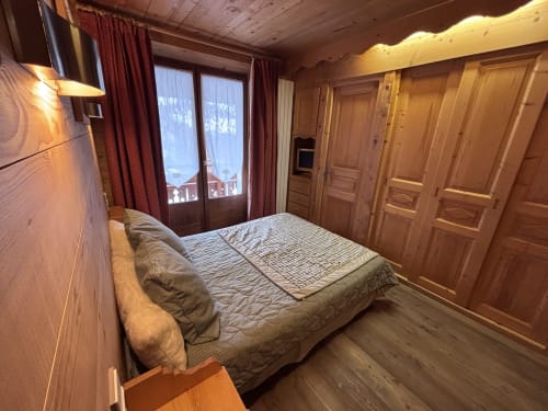 Spacieuse chambre en bois Chez Francine avec lit queen-size, balcon vue montagne et décor alpin traditionnel à Notre Dame de