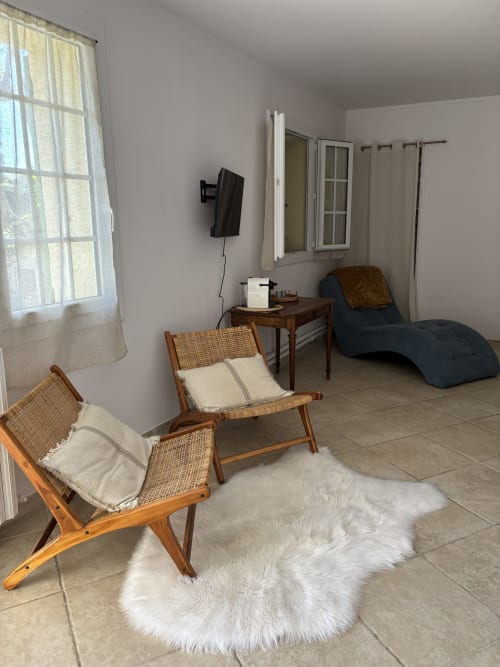 Chambre Jasmin à la Maison d'hôtes Le Mas des Vignes avec chaises tressées, méridienne bleue et vue sur le jardin à Rochegude