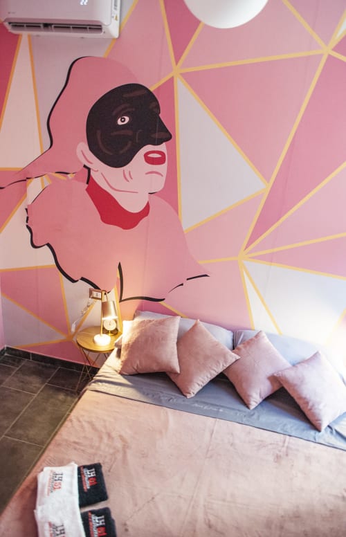 Camera da letto colorata presso LH51 Rooms a Napoli con arte geometrica rosa, cuscini e lampada dorata
