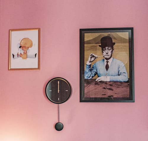 Parete rosa con opere d'arte incorniciate, orologio a pendolo e ritratto nella camera Pulcinella della locanda LH51 a Napoli