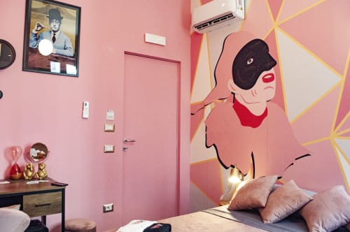 Camera da letto rosa presso LH51 Napoli con murale pop art di donna mascherata, letto, scrivania e opere d'arte