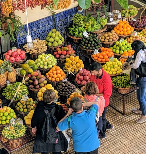 Vibrante banca de mercado de frutas em Funchal com produtos tropicais frescos: bananas, cítricos e frutas coloridas