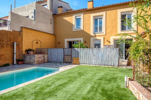 Palafrugell villa with swimming pool, green lawn, and yellow Mediterranean facade - Finques Garcia Enrich