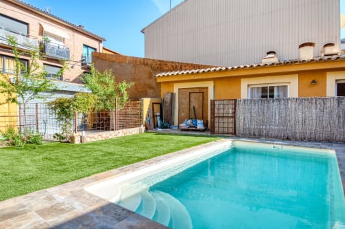 Swimming pool and garden at Finques Garcia Enrich hotel in Palafrugell with yellow cottage and terrace