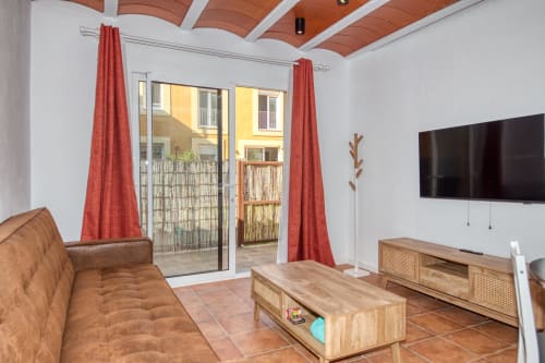 Modern living room at Finques Garcia Enrich hotel in Palafrugell with terrace access, brown sofa, and wooden furniture