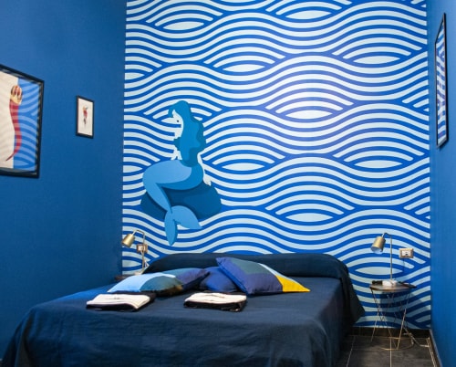 Camera Partenope presso LH51 Napoli con decorazioni murali a onde blu, murale di balena e biancheria da letto blu navy