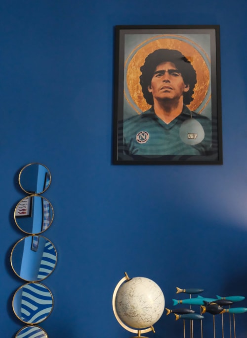 Arredamento a tema napoletano presso LH51 con opere d'arte religiosa e piatti decorativi rigati su parete blu