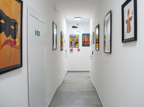 Moderno corridoio di LH51 Rooms and Apartments a Napoli con opere d'arte incorniciate, porte bianche e coloratissimi quadri contemporanei