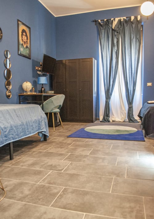 Spaziosa camera moderna presso LH51 Rooms a Napoli con pareti blu, armadio scuro e arredi eleganti