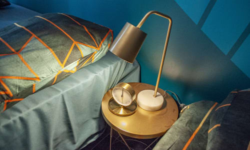 Brass bedside table with clock and lamp in Vesuvio's Room at LH51 Rooms, Naples