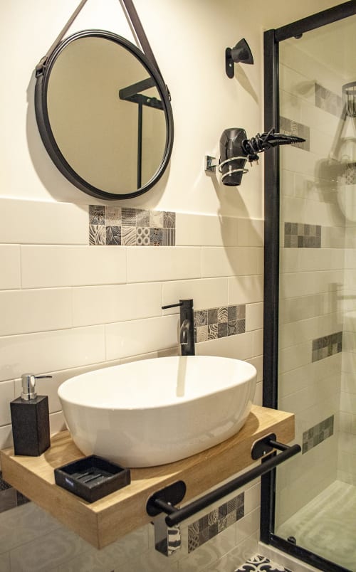Modern bathroom in Vesuvio's Room at LH51 Rooms and Apartments Naples, featuring white vessel sink, black fixtures, and