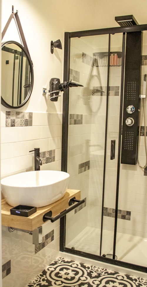 Modern bathroom in Vesuvio's Room at LH51 Napoli with walk-in shower, vessel sink, and black fixtures