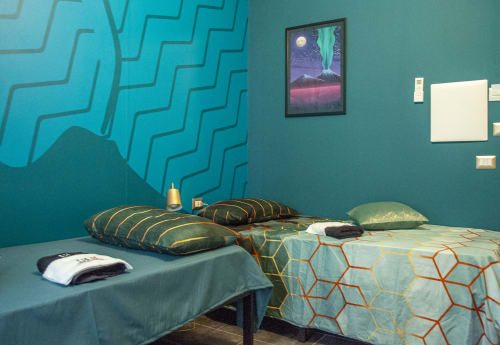 Vesuvio's Room at LH51 in Naples with teal walls, geometric patterns, modern bedding, and volcano artwork