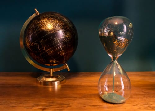 Decorative globe and hourglass on wooden table at LH51 Rooms in Naples, Vesuvio's Room