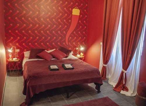 Lussuosa camera da letto rossa presso LH51 Rooms a Napoli con arredi eleganti, illuminazione d'atmosfera e servizi moderni