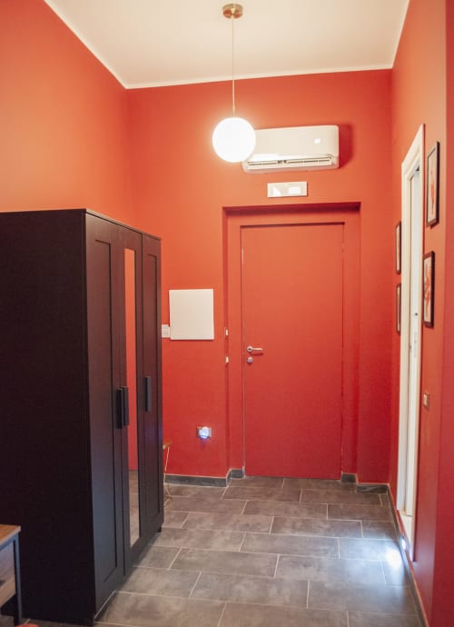 Moderno corridoio rosso in LH51 Naples B&B con lampada a sospensione, climatizzazione e pavimentazione in piastrelle scure