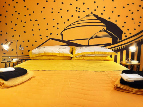 Bright yellow bedroom at LH51 Rooms in Naples with modern dome mural and black polka dot wallpaper