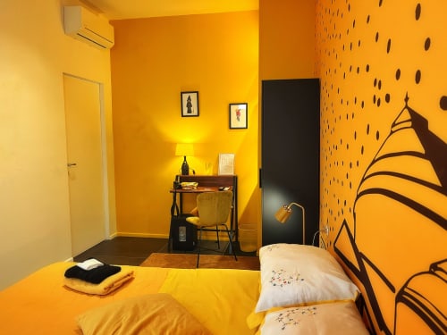 Camera da letto giallo brillante presso LH51 Rooms a Napoli con arredo moderno e dettagli neri