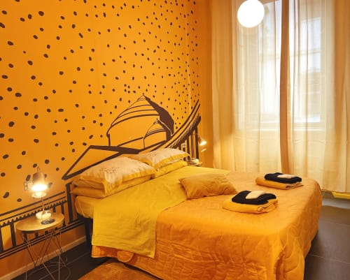 Camera da letto giallo brillante presso LH51 Napoli con decorazioni a pois, letto moderno e finestra con luce naturale