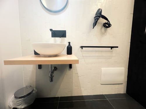 Bagno moderno presso LH51 Rooms a Napoli con lavabo a bacinella, ripiano in legno e design minimalista con piastrelle bianche e nere