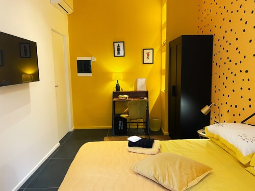 Camera da letto giallo brillante alle LH51 Rooms di Napoli con letti gemelli, scrivania moderna e parete accent a pois neri