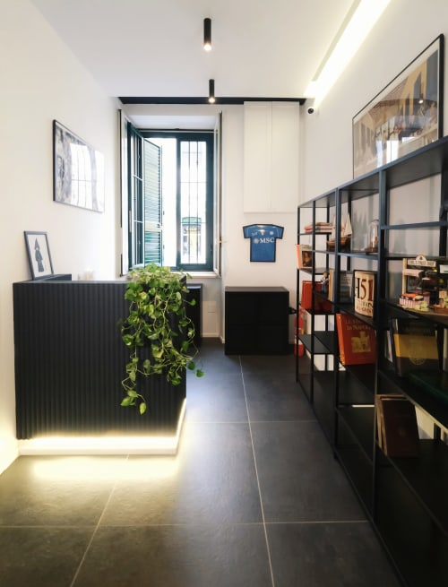 Modern hallway at LH51 Rooms, Naples featuring black shelving, green plant, and minimalist design
