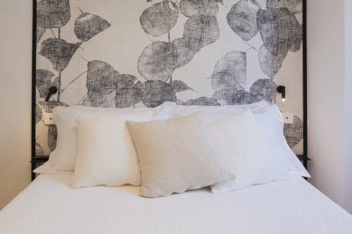 Letto di Palazzo Garibaldi Parma con testata decorativa a motivi floreali e biancheria neutra