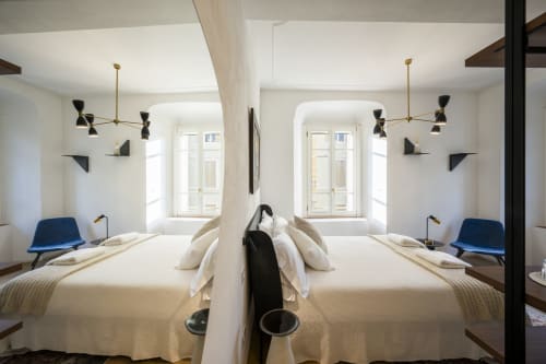 Chambre d'hôtel moderne au Palazzo Garibaldi Parma avec lits jumeaux, luminaires suspension en laiton et fauteuils bleus