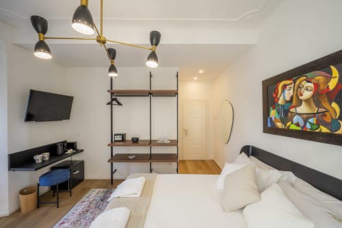 Chambre moderne du Palazzo Garibaldi Parma avec lit, bureau, étagères et artwork coloré aux murs