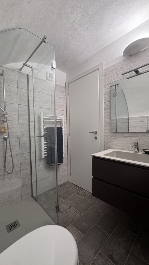 Bagno moderno della Residenza a Talking Stones a Dolceacqua con doccia in vetro, vanity nera e stile contemporaneo