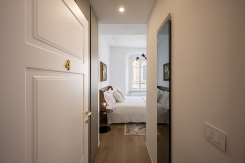 Vue du couloir d'une chambre de l'hôtel Palazzo Garibaldi Parma, avec parquet et mobilier moderne
