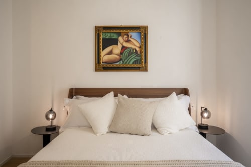 Chambre élégante du Palazzo Garibaldi Parma avec literie blanche, tête de lit en bois et œuvre d'art classique