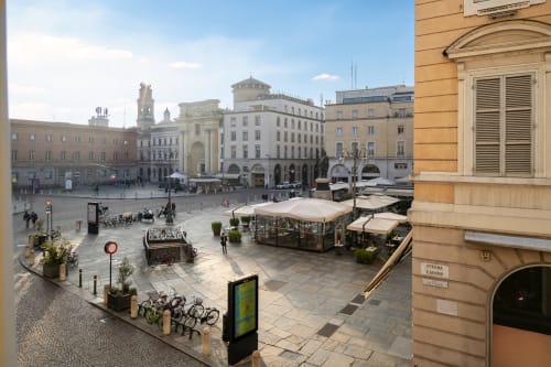 Piazza Garibaldi à Parme avec bâtiments historiques, terrasse de café et vélos près de l'hôtel Palazzo Garibaldi