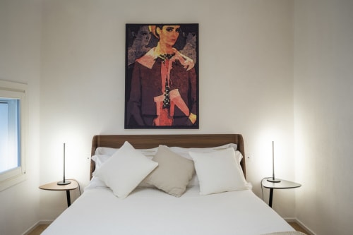 Chambre d'hôtel moderne au Palazzo Garibaldi Parma avec lit en bois, literie blanche et tableau portrait contemporain