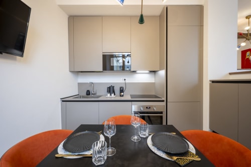 Cuisine et salle à manger modernes au Palazzo Garibaldi Parma avec chaises orange et table noire
