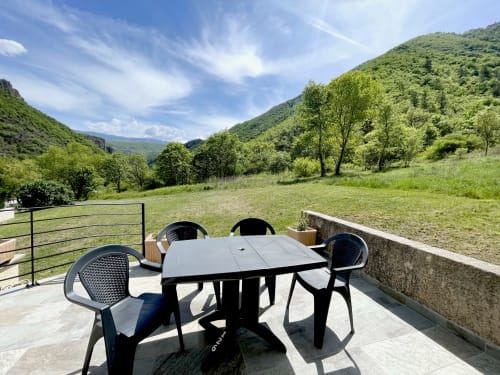 Terrasse extérieure avec table de salle à manger au pavillon Vallon des Sources, Digne-les-Bains, vue sur les vallées montagneuses