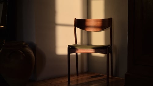 Mid-century wooden chair with green seat in sunlit room at Moulin Renaudiots hotel, Autun