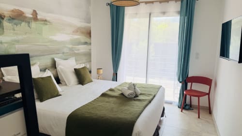Chambre de villa moderne avec vue sur la piscine, literie vert olive, rideaux bleu canard et décor contemporain aux Villas Vallée d'Asco