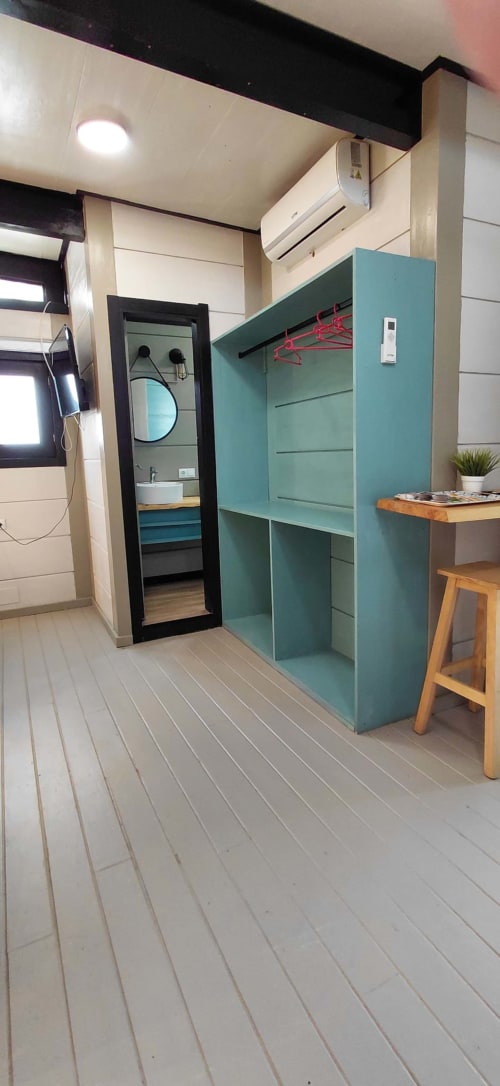 Interior moderno de cabaña en Villa Palma Marbella con armario turquesa, zona de cocina y entrada al baño