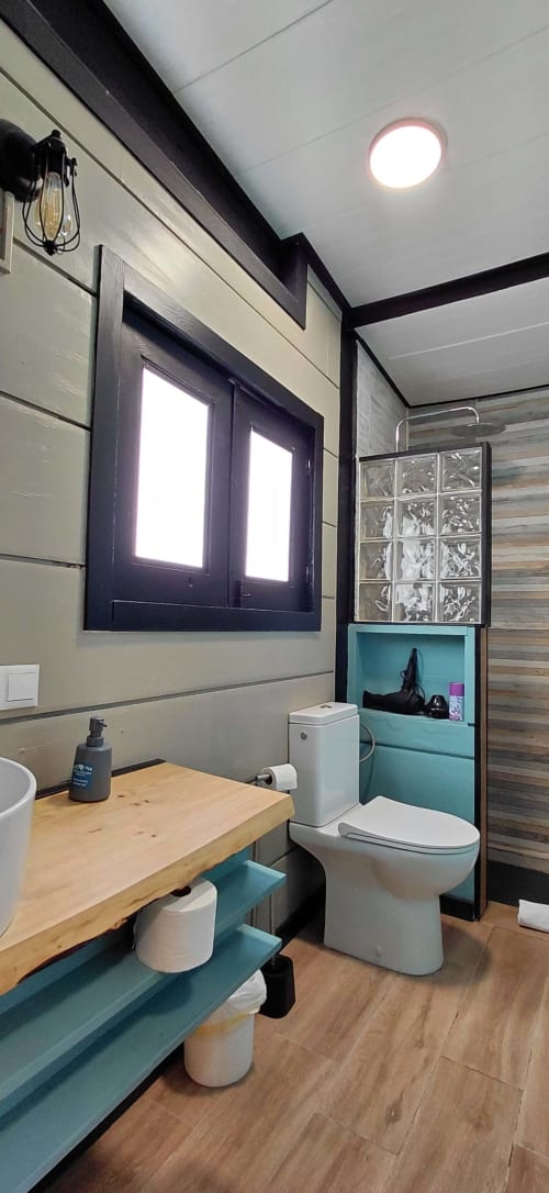 Baño moderno en Cabaña 6 de Villa Palma, Marbella, con tocador de madera, detalles en turquesa y equipamiento contemporáneo