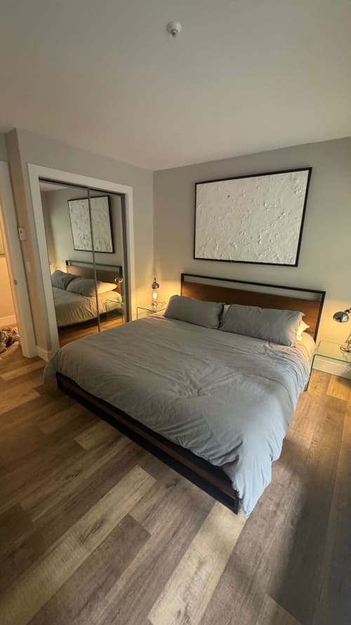 Modern bedroom at Northstar 37 Whistler with queen bed, wood flooring, and mirrored closet entry